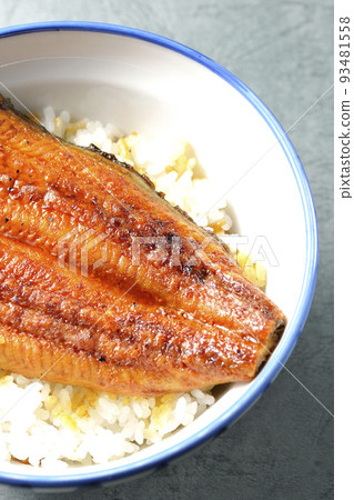 A bird's-eye view of a simple eel bowl with grilled eel on top of white rice 93481558