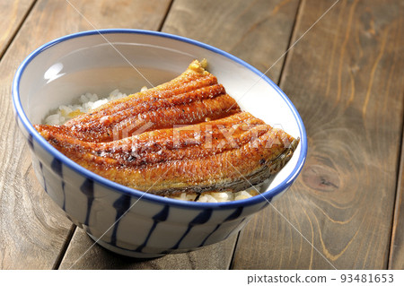 A simple eel rice bowl with grilled eel on top of white rice. 93481653