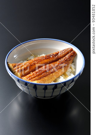 A simple eel bowl with grilled eel on top of white rice, photographed against a black background A simple eel bowl with grilled eel on top of white rice, photographed against a black background 93481852