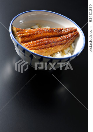 A simple eel bowl with grilled eel on top of white rice, photographed against a black background A simple eel bowl with grilled eel on top of white rice, photographed against a black background 93481859