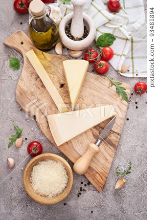 Parmesan cheese and knife on a wooden cutting board 93481894