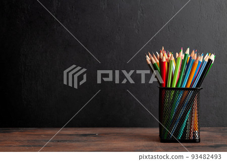 Colorful pencils on wooden table and blackboard Colorful pencils on wooden table and blackboard 93482493