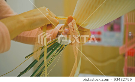 Female florist makes flower bunch, she cuts off wrapping paper w Female florist makes flower bunch, she cuts off wrapping paper w 93482799