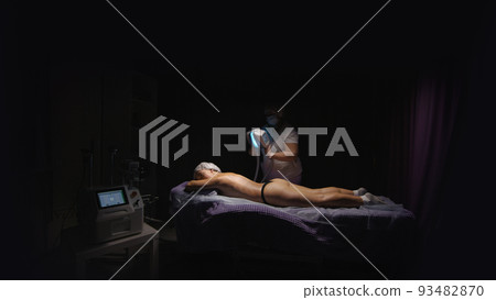Woman getting cryolipolysis anti-fat anti-cellulite freezing treatment procedure in spa salon. Hardware cosmetology 93482870