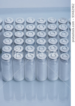 Glass medical ampoule vial for injection. Medicine is dry white drug penicillin powder or liquid with of aqueous solution in ampulla. Close up. 93482962