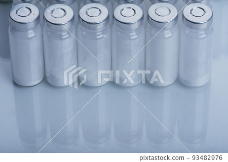 Glass medical ampoule vial for injection. Medicine is dry white drug penicillin powder or liquid with of aqueous solution in ampulla. Close up. Glass medical ampoule vial for injection. Medicine is dry white drug penicillin powder or liquid with of aqueous solution in ampulla. Close up. 93482976