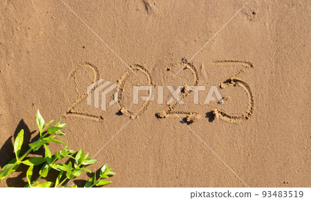 The numbers 2023 are written on the sand on the beach. The concept of the New Year. Happy New Year 2023 background. Travel during the Christmas holidays. 93483519