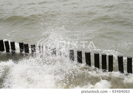 Breakwaters in the sea. Waves beat against breakwaters. 93484083