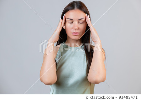 Young beautiful woman has headache, isolated on gray background. Exhausted girl portrait 93485471