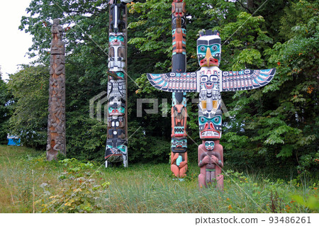 Colored and traditional totem poles in Stanley Park 93486261