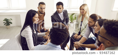 Business coach speaking about teamwork during meeting with group of young people 93487162