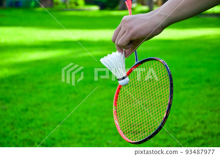 Shuttlecock holding by hand in front of the racket and ready to be served Shuttlecock holding by hand in front of the racket and ready to be served 93487977