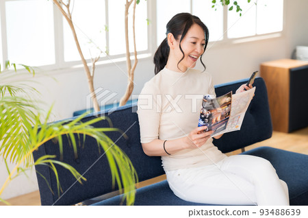 Middle woman thinking while looking at a pamphlet Middle woman thinking while looking at a pamphlet 93488639