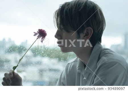 A man relaxing by the window on a rainy day 93489097