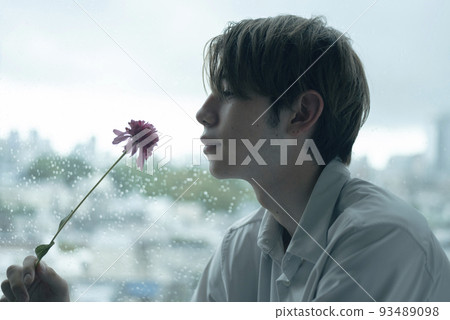 A man relaxing by the window on a rainy day 93489098