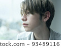 A man relaxing by the window on a rainy day 93489116