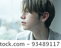 A man relaxing by the window on a rainy day 93489117