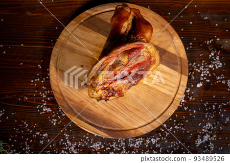 juicy smoked pork shank, delicious meat appetizer, sliced pieces on a wooden board, food,copy space juicy smoked pork shank, delicious meat appetizer, sliced pieces on a wooden board, food,copy space 93489526