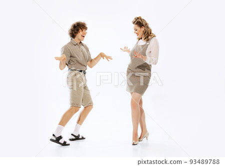 Expressive couple of dancers in vintage retro style outfits dancing social dance isolated on white background. Timeless traditions, 60s ,70s american fashion style. 93489788