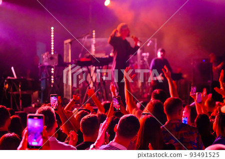 Crowd dancing near stage during concert 93491525