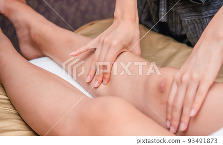 Legs of a young woman receiving a manipulative massage 93491873