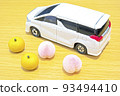 A white car and pear and peach miniatures placed on the desk 93494410