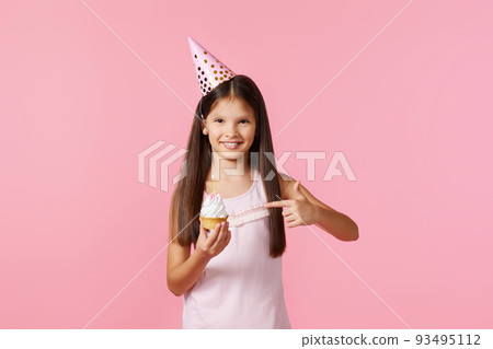 happy little birthday girl with party cone holding cupcake happy little birthday girl with party cone holding cupcake 93495112