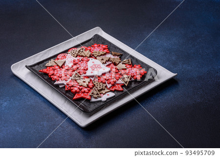 Christmas decorations and gingerbreads on a dark concrete table. Getting ready to celebration Christmas decorations and gingerbreads on a dark concrete table. Getting ready to celebration 93495709