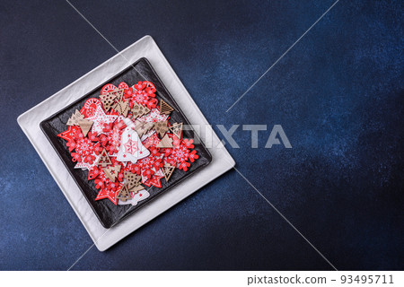 Christmas decorations and gingerbreads on a dark concrete table. Getting ready to celebration Christmas decorations and gingerbreads on a dark concrete table. Getting ready to celebration 93495711