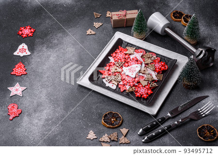 Christmas decorations and gingerbreads on a dark concrete table. Getting ready to celebration Christmas decorations and gingerbreads on a dark concrete table. Getting ready to celebration 93495712