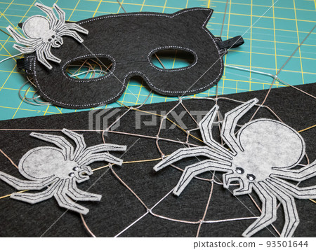 Mask and spiders from felt as the decoration for the Halloween Festival 93501644