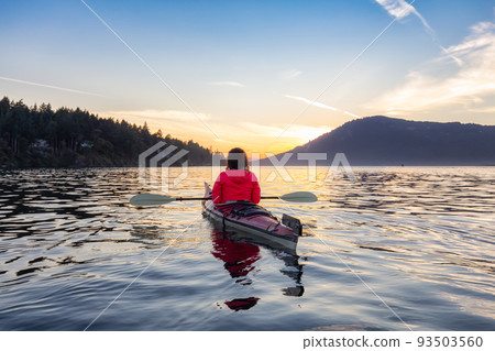 Adventurous Woman on Sea Kayak paddling in the Pacific Ocean. Sunny Summer Sunset Adventurous Woman on Sea Kayak paddling in the Pacific Ocean. Sunny Summer Sunset 93503560