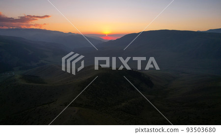 Red rays of the sun at sunset among the mountains 93503680