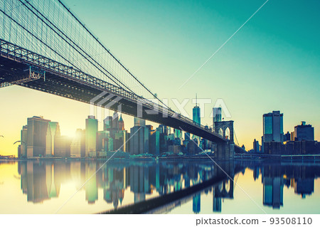 View of Brooklyn Bridge and Manhattan skyline WTC Freedom Tower from Dumbo at sunset, Brooklyn. Brooklyn Bridge is one of the oldest suspension bridges. 93508110