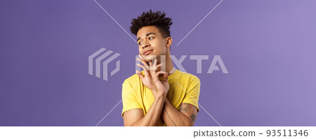Close-up portrait of glamour beautiful young queer guy with dreads, standing in feminine model pose, gently touching face and looking away sensual, standing purple background 93511346