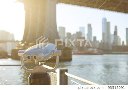 View of Manhattan bridge and New York City with a coin operated telescope binoculars viewer for tourists. View of Manhattan bridge and New York City with a coin operated telescope binoculars viewer for tourists. 93512091