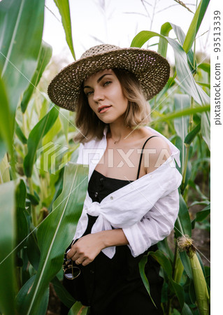 Portrait of young stylish woman in green jungle. Girl in straw hat, linen clothes. Lady looks happy Portrait of young stylish woman in green jungle. Girl in straw hat, linen clothes. Lady looks happy 93513339