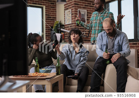 Group of diverse friends feeling sad about lost video games play, using vr glasses and tv console to have fun with competition game. People gathering at fun party, losing game together. 93516908