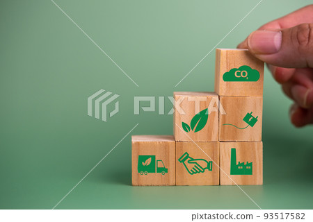 Hand holding wood cube block icon co2 carbon credit and eco energy green technology on green background. Hand holding wood cube block icon co2 carbon credit and eco energy green technology on green background. 93517582