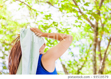 A woman sweating with a towel A woman sweating with a towel 93519579