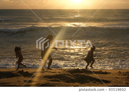 Happy Asian family of mother and daughters having fun playing on the beach during summer vacation at sunset. Summer family trip to the beach. travel and vacation concept. 93519602
