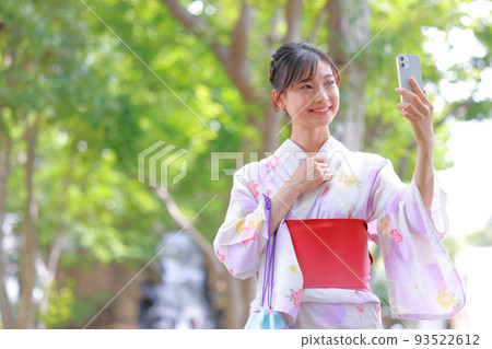 A woman in a yukata talking on a videophone_Middle 2 A woman in a yukata talking on a videophone_Middle 2 93522612