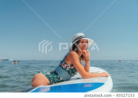 SUP Stand up paddle board. Young woman sailing on beautiful calm sea with crystal clear water. The concept of an summer holidays vacation travel, relax, active and healthy life in harmony with nature. 93527153