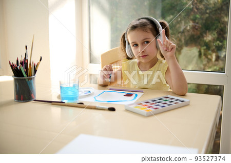 Charming talented European little girl of preschool wearing wireless headphones and yellow t-shirt, enjoying creative courses, learning watercolor painting. Art class. Hobby and leisure activity Charming talented European little girl of preschool wearing wireless headphones and yellow t-shirt, enjoying creative courses, learning watercolor painting. Art class. Hobby and leisure activity 93527374