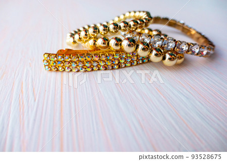 a lot of gold costume jewelry with different materials on a white background. Copy space 93528675