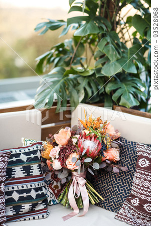 Beautiful wedding bouquet and pillows on the sofa Beautiful wedding bouquet and pillows on the sofa 93528968