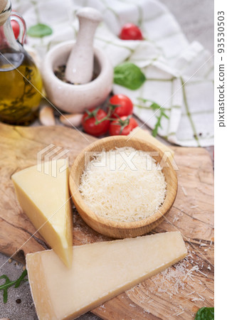 Grated Parmesan cheese on a wooden cutting board at domestic kitchen Grated Parmesan cheese on a wooden cutting board at domestic kitchen 93530503