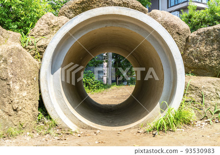 A large clay pipe placed in a park 93530983