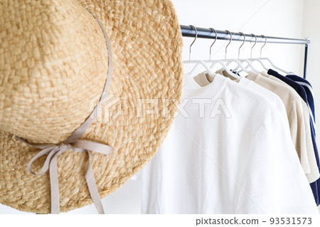 Clothes and hats lined up on a hanger rack 93531573