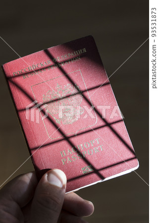 Russian passport in the hands of a man. Prohibition of Schengen visas for Russian tourists to travel to the European Union concept. 93531873